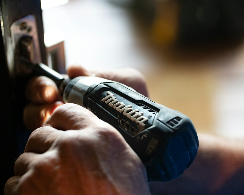 Engineer's hands using a cordless drill on an appliance